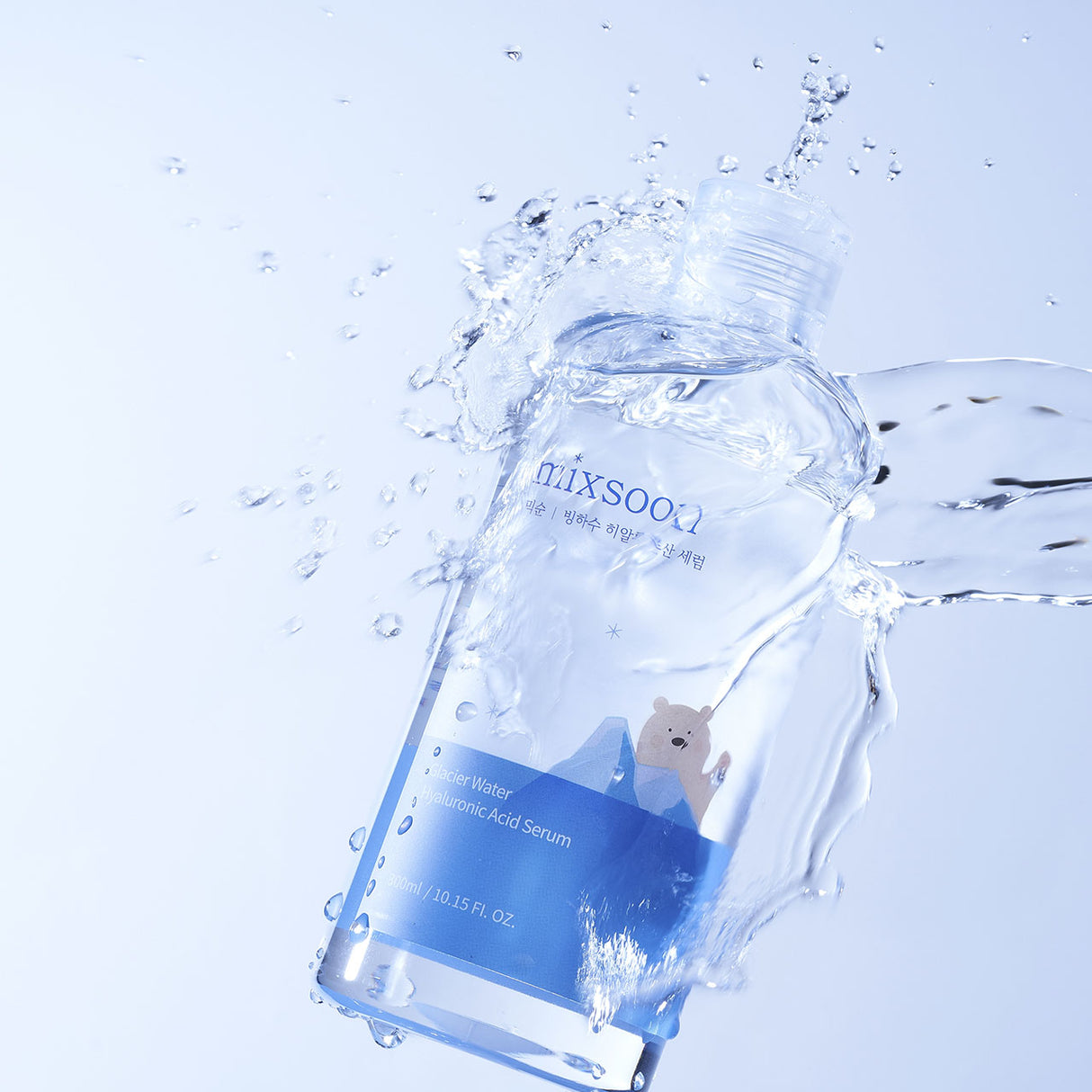 "Flacone del siero Mixsoon Glacier Water Hyaluronic Acid Serum avvolto da spruzzi d'acqua su sfondo azzurro, enfatizzando la freschezza e l'idratazione del prodotto. L'etichetta mostra un orso polare stilizzato tra i ghiacci."