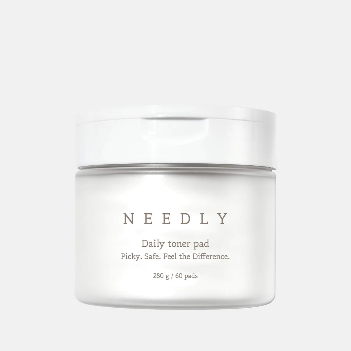 Vasetto bianco opaco del prodotto "Needly Daily Toner Pad" con coperchio bianco lucido, contenente 60 dischetti imbevuti di tonico (280 g). Sul fronte è riportato il claim: "Picky. Safe. Feel the Difference."