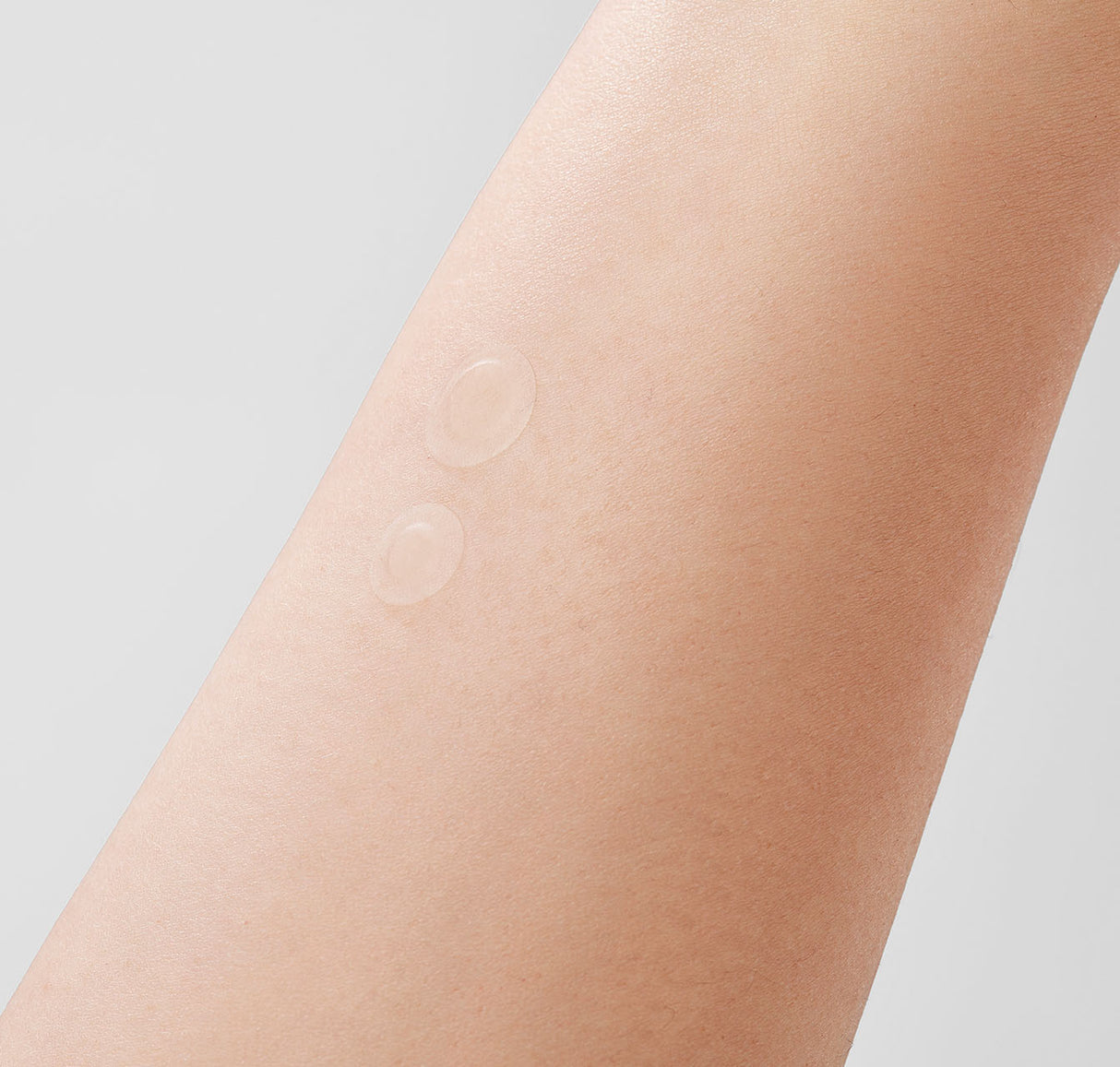 Due cerotti trasparenti Mixsoon Spot Cleancare Patch applicati sulla pelle nuda, visibili a contatto con la superficie cutanea su sfondo chiaro.