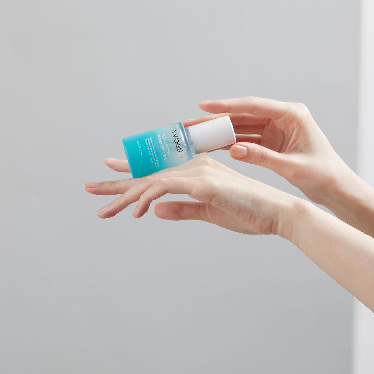 boccetto azzurro vvbetter siero orizzontale su mani e sfondo bianco