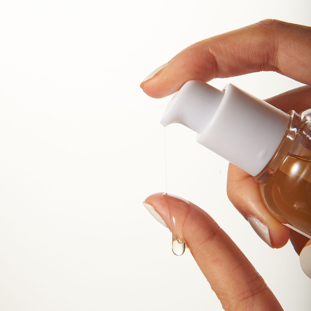 Primo piano della Mixsoon Bifida Essence mentre viene erogata su un dito, mostrando una goccia trasparente e la consistenza leggera del prodotto