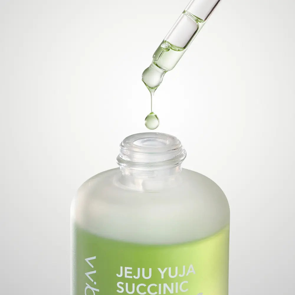 Immagine prodotto del siero viso Jeju Yuja Succinic Balancing Serum di Whalette, flacone contagocce verde posato su superficie con texture liquida. Siero illuminante e riequilibrante formulato con estratto di yuja di Jeju e acido succinico, ideale per migliorare luminosità e uniformità della pelle.