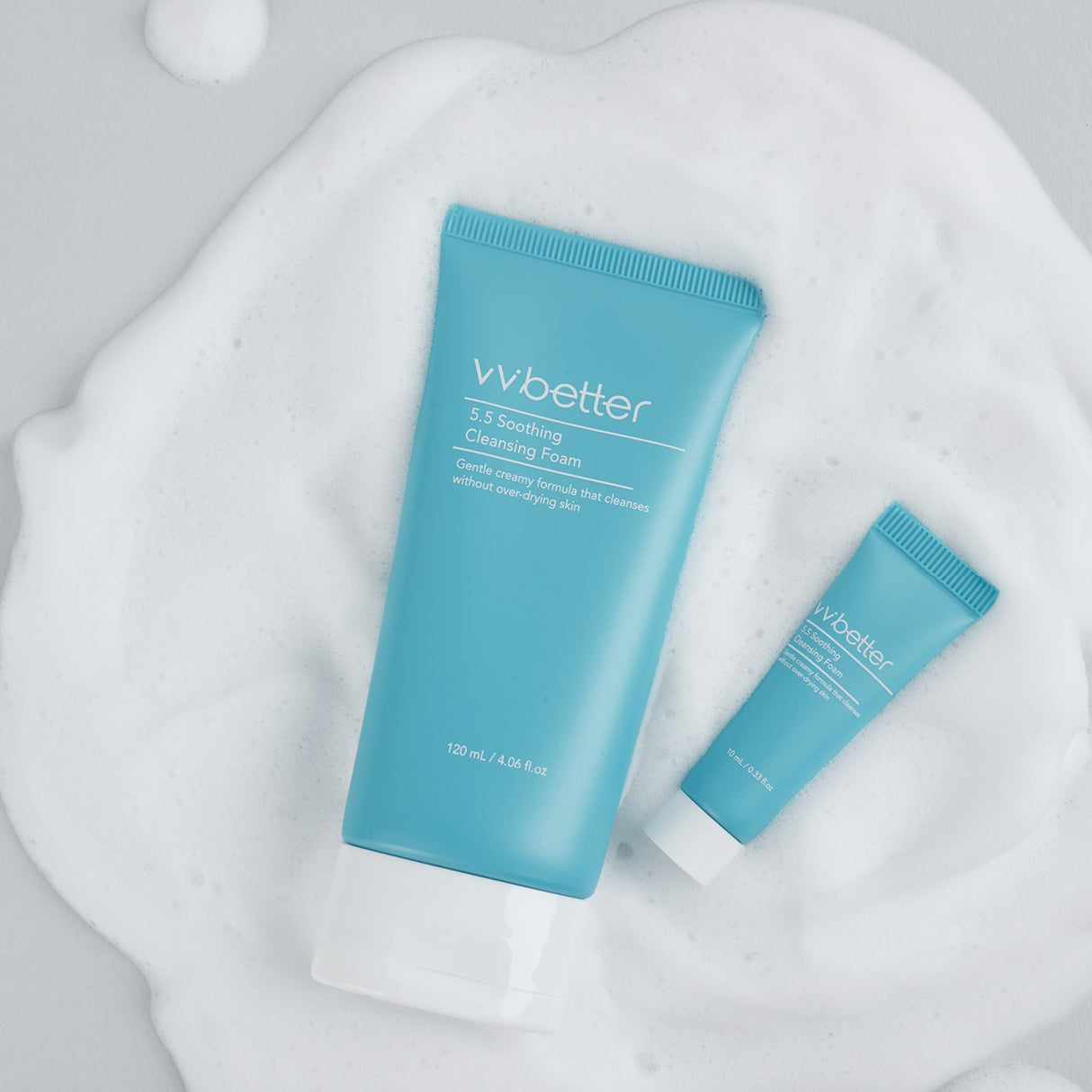 Due tubi del vvbetter 5.5 Soothing Cleansing Foam, uno grande da 120 ml e uno piccolo da 10 ml, posizionati su uno sfondo coperto di morbida schiuma bianca, evidenziando le dimensioni disponibili e la texture cremosa del prodotto.