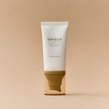 Un tubetto bianco con tappo dorato trasparente del prodotto “Skin1004 Madagascar Centella Air-Fit Suncream Light” è posizionato frontalmente su uno sfondo bianco. Il design è minimal e pulito, con scritte nere centrali.