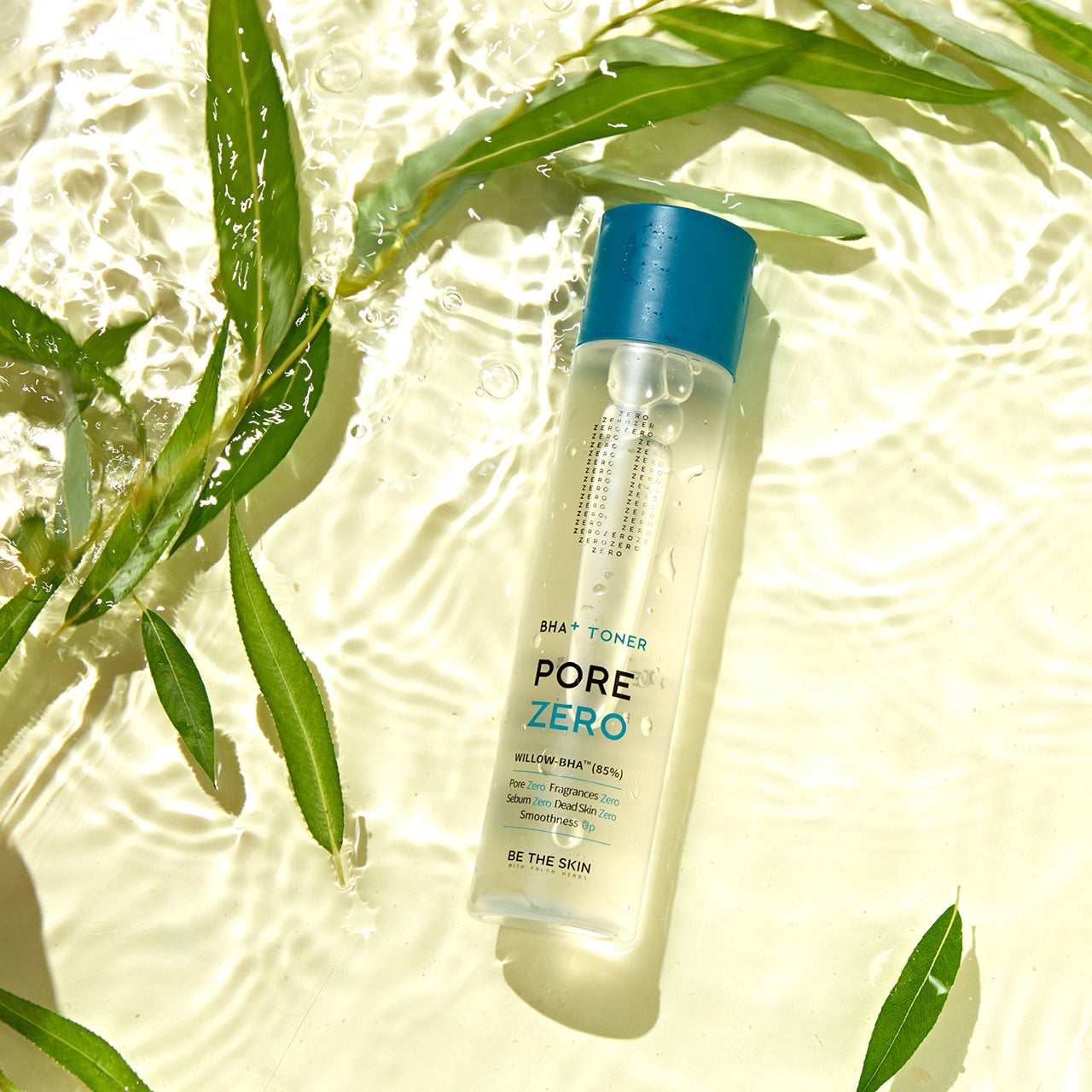Flacone del tonico BE THE SKIN Pore Zero BHA+ immerso parzialmente in acqua con riflessi di luce e foglie verdi, che evocano freschezza e purezza.