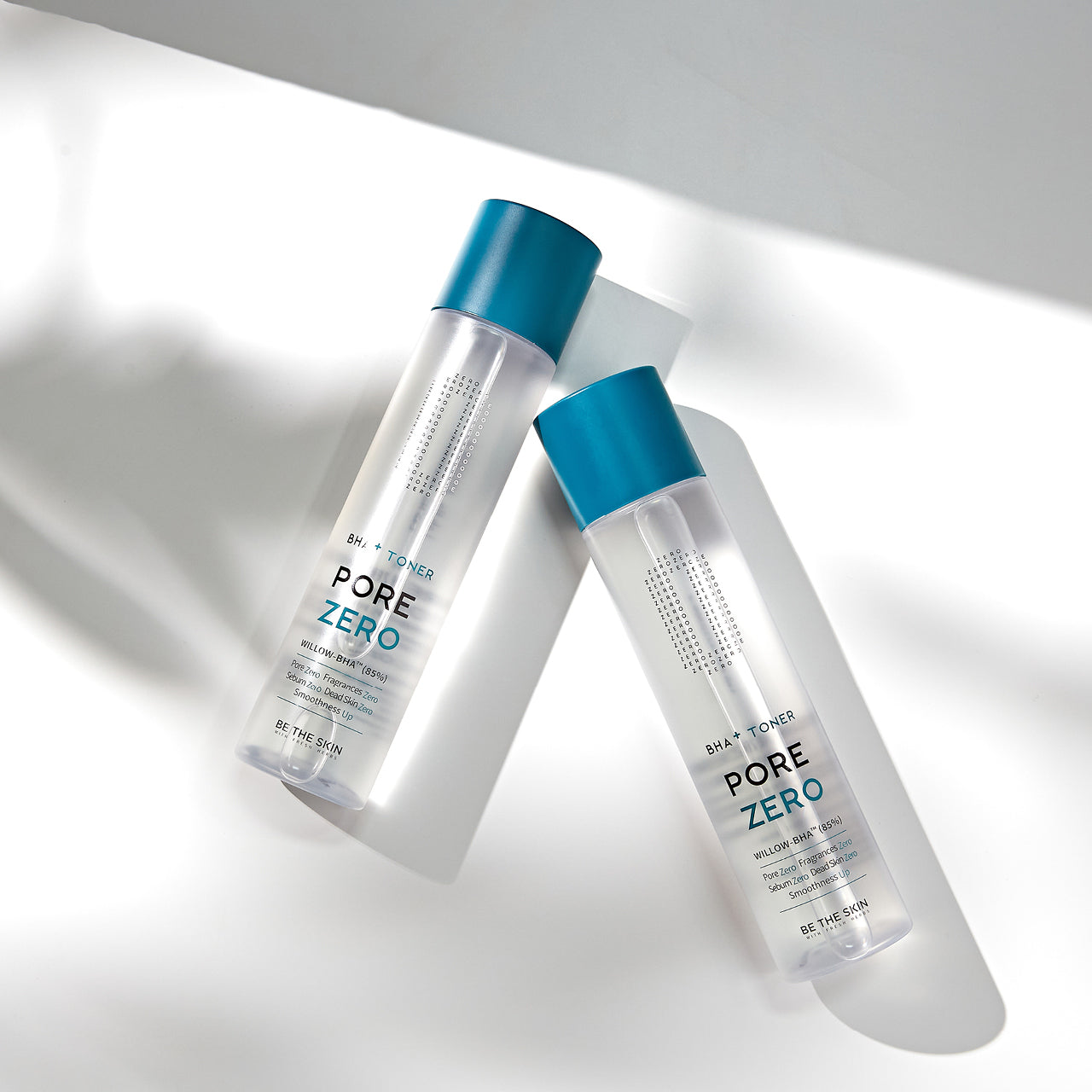 Due flaconi di toner Pore Zero BHA+ Toner di Be The Skin disposti su superficie bianca con ombre leggere, tappo blu e design minimal.