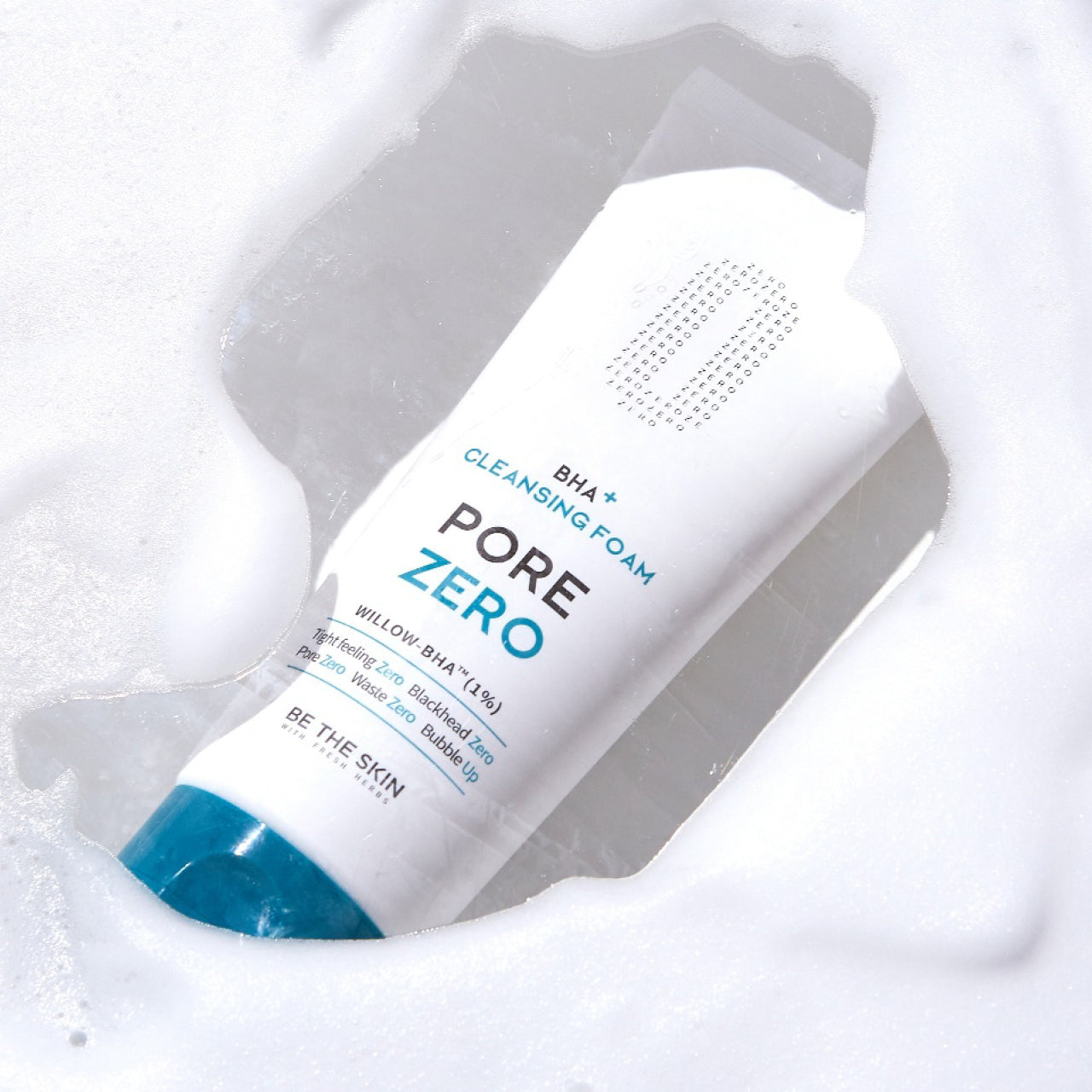 Detergente viso BE THE SKIN PORE ZERO BHA+ CLEANSING FOAM immerso nella schiuma, con il tappo blu visibile in primo piano.