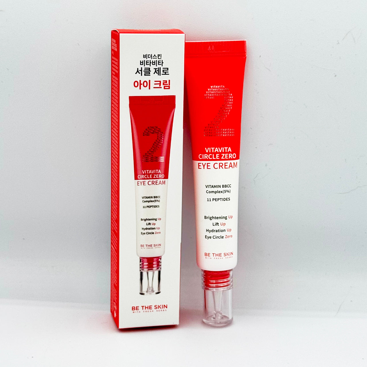 Crema contorno occhi "Vitavita Circle Zero Eye Cream" del brand Be The Skin, presentata accanto alla sua confezione. Il tubetto è rosso e bianco, con scritte che indicano la presenza di Vitamin BBCC Complex (5%) e 11 peptidi, e promesse di effetti come illuminazione, effetto liftante, idratazione e riduzione delle occhiaie.


