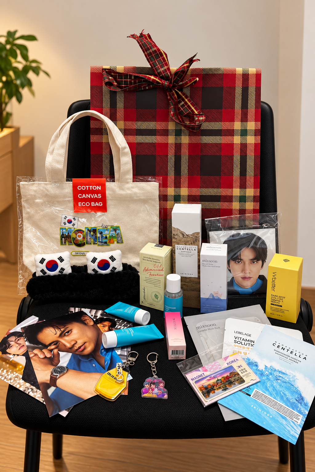 Contenuto del calendario dell'avvento K-Dream 24 giorni: skincare coreana, photocard K-Pop, borsa in tela e gadget coreani accanto alla confezione regalo scozzese