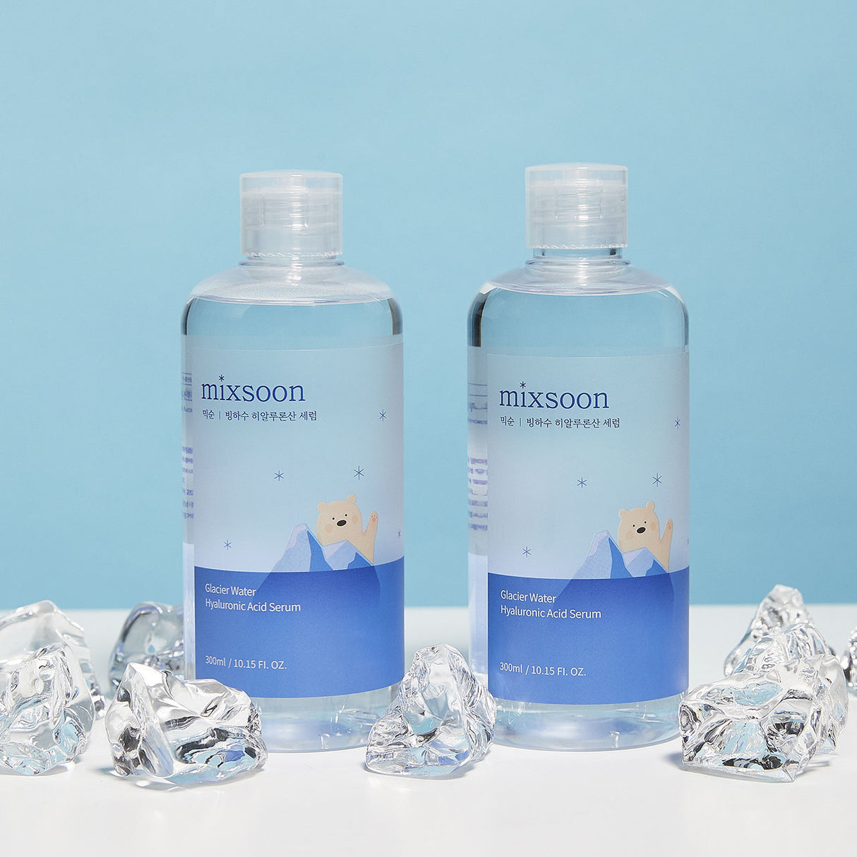 Glacier Water hyaluronic Acid Serum 2 flaconi trasparenti con etichetta blu con orso polare disegnato con ghiacciaio  su sfondo azzurrino con ghiaccio su tavolo bianco