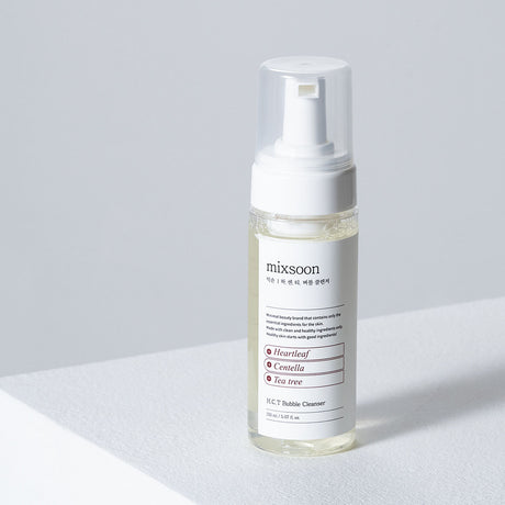 "Flacone del detergente Mixsoon H.C.T. Bubble Cleanser da 150 ml appoggiato su una superficie bianca, con sfondo grigio chiaro minimalista."

