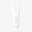 Tubo bianco minimalista della crema viso "Needly Panthenol Water Gel Cream", con tappo argentato e scritta verticale color grigio, su sfondo chiaro neutro.
