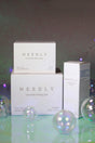 Set skincare Needly con Cicachid Relief Cream 48 ml, Cicachid Chilling Pad 70 pads e Cicachid Soothing Ampoule 30 ml, confezioni minimal su sfondo iridescente con bolle traslucide decorative.