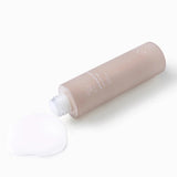 Flacone coricato del tonico viso SOROCI Repair Skin Softener Organic Rice, con tappo rimosso e prodotto fuoriuscito su sfondo bianco.