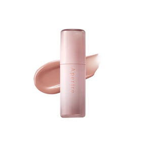 Lip tint Aperire con packaging rosa sfumato posizionato davanti a una texture nude cremosa su sfondo chiaro