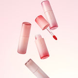 Flaconi di lip tint Aperire rosa gradient disposti in aria con applicatore doe-foot e prodotto visibile, su sfondo minimal bianco
