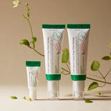 Tre tubetti di siero AXIS-Y Dark Spot Correcting Glow Serum in formati diversi, disposti in verticale su sfondo beige con decorazioni naturali e rampicanti verdi, che trasmettono un’estetica botanica e naturale del brand.

