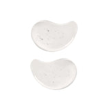 Patch occhi in idrogel trasparenti fotografate su sfondo chiaro, con texture gelatinosa e forma anatomica visibile
