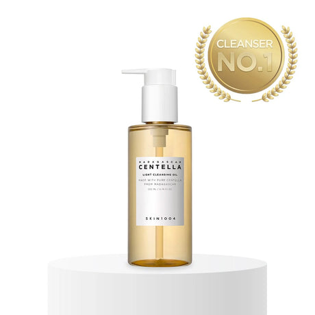 Flacone del detergente SKIN1004 Madagascar Centella Light Cleansing Oil da 200ml con pompa bianca, posizionato su piedistallo bianco con badge dorato “Cleanser No.1” su sfondo chiaro.