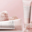 Tubo da 125ml del detergente SKIN1004 Madagascar Centella Poreminizing Deep Cleansing Foam con una dose di prodotto schiumoso sulla parte superiore, su sfondo rosa perlato.