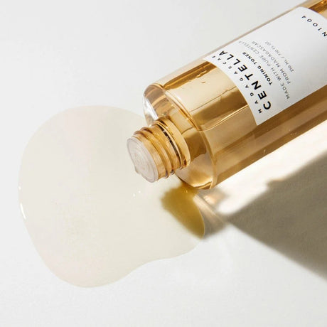 “
Toner viso alla centella asiatica FOODAHOLIC da 210 ml, flacone trasparente rovesciato con liquido versato su fondo chiaro, skincare coreana idratante e leniti