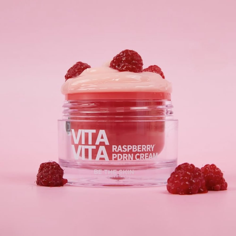Barattolo aperto di Vita Vita Raspberry PDRN Cream Be The Skin con lamponi su sfondo rosa

