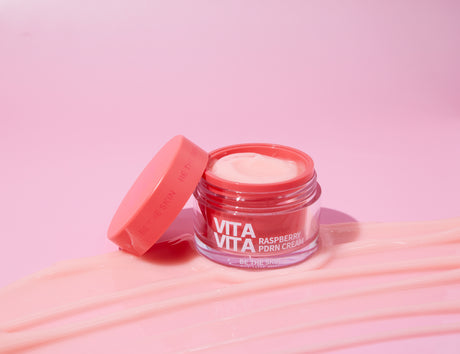 Barattolo aperto di Vita Vita Raspberry PDRN Cream Be The Skin con tappo appoggiato su sfondo rosa