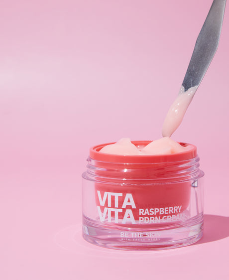 Texture della Vita Vita Raspberry PDRN Cream Be The Skin prelevata dal barattolo con spatola su sfondo rosa