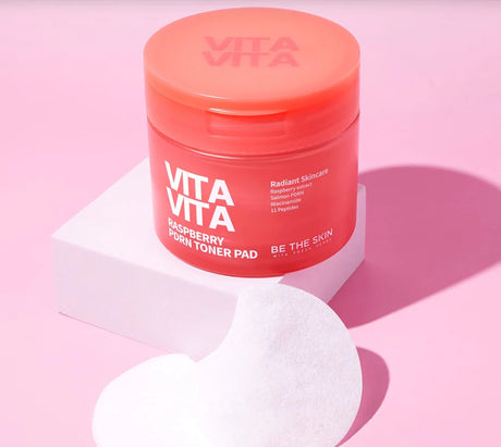 Barattolo di Vita Vita Raspberry PDRN Toner Pad Be The Skin su sfondo rosa