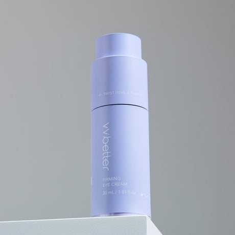 Flacone color lavanda del vvbetter Firming Eye Cream da 30 ml / 1.01 fl.oz., posizionato su una superficie bianca contro uno sfondo neutro, con la scritta “TWIST HERE & PUMP IT” visibile sulla parte superiore.